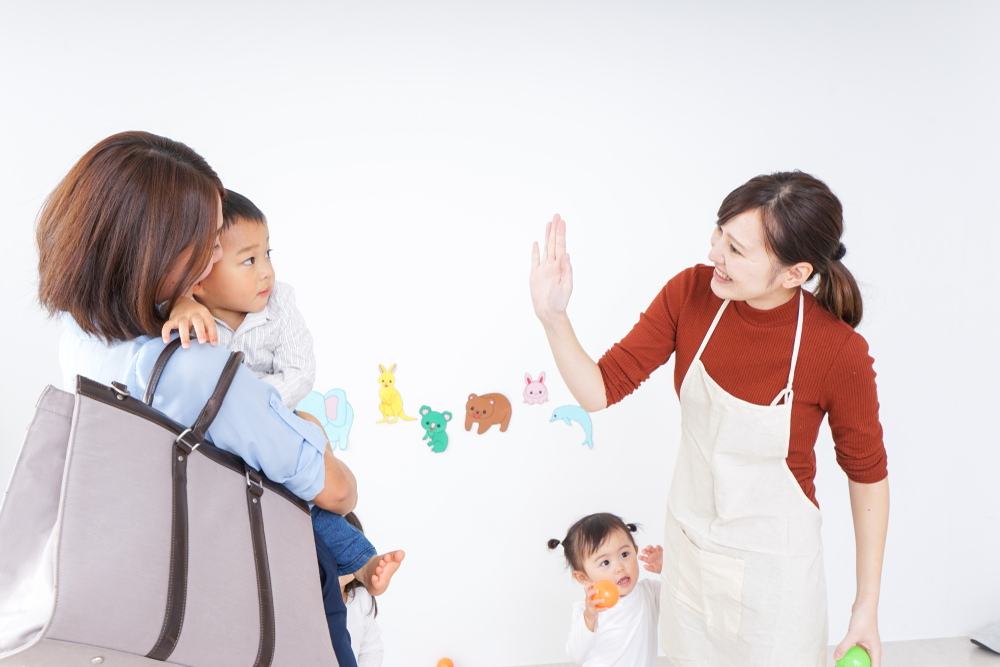 Mother holding her anxious child for drop off at daycare.
